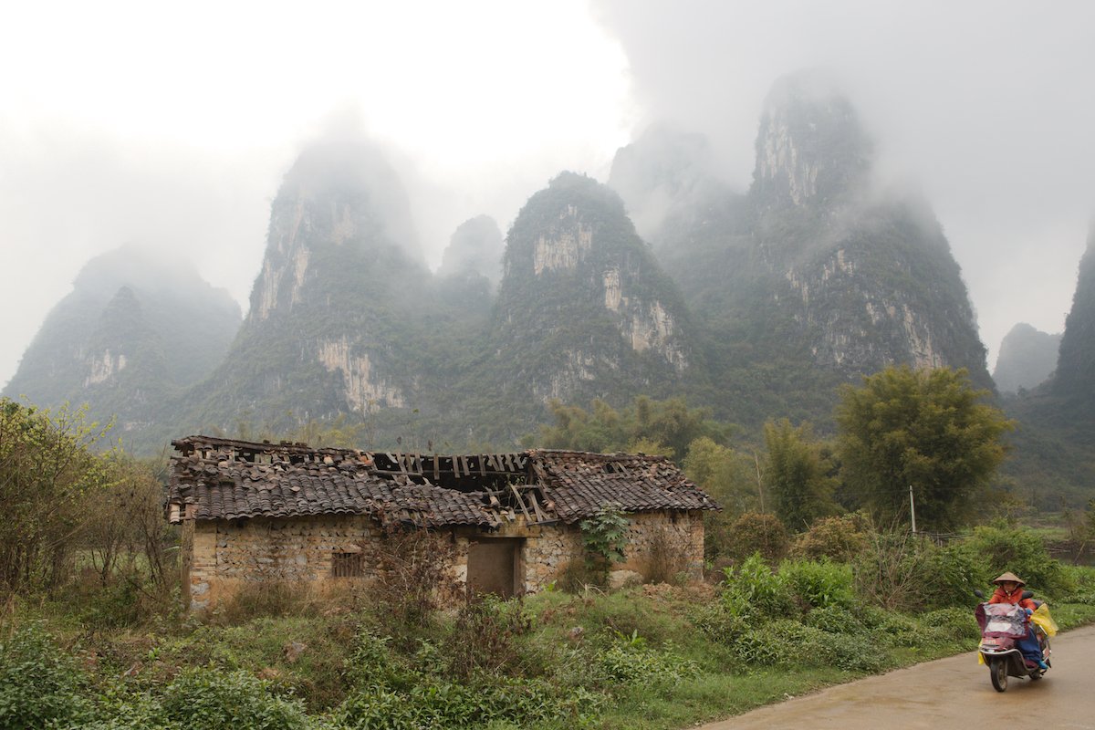 Highlights recovered in a photo of motorcyclist in a rural area with building and karsts using AfterShot Pro 3